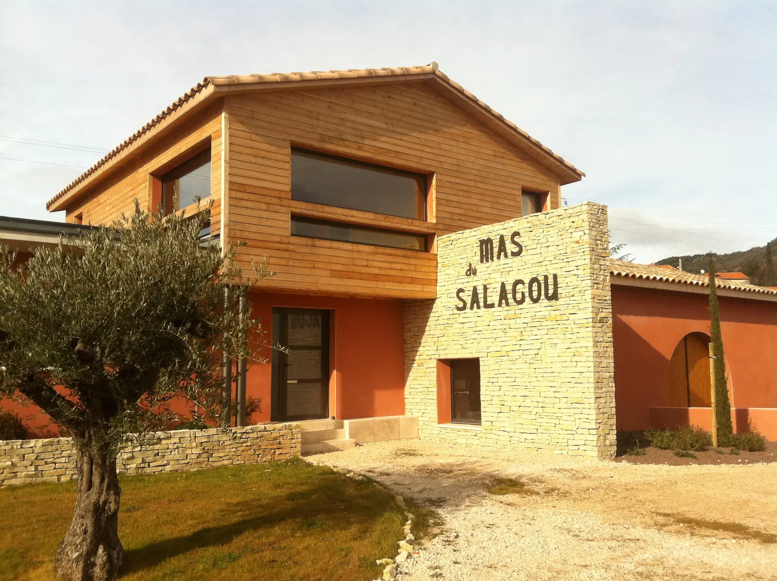 Maison d'affinage — Mas Salagou — Pierre, bois et enduits ocres face aux paysages rouges du Salagou.